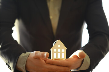Real estate agent holding a toy house