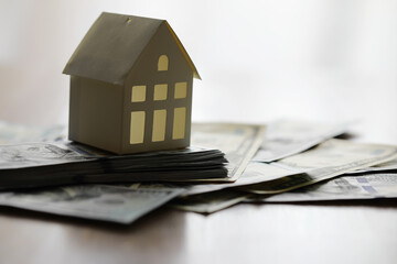 Model of cardboard house with key and dollar bills. Building, loan, real estate, cost of housing or buying a new home concept.