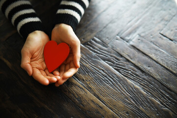 Hands of a woman holding and offering a heart shape. Love, health concept. Selective...