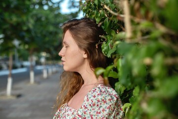 Portrait of beautiful young woman in dress is enjoy summer or spring day on natural green natural...
