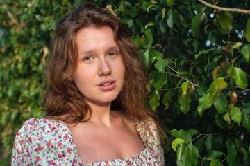 Portrait of beautiful young woman in dress is enjoy summer or spring day on natural green natural...