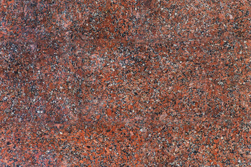 The area of the processed granite surface is red with black and gray patches.