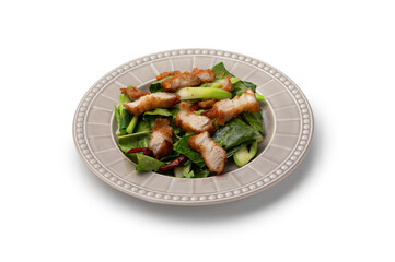 Fried kale with crispy pork belly in a brown ceramic plate