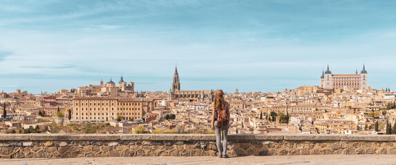 Panorama of Toledo city landscape in Spain and woman standing contempling impressive view - obrazy, fototapety, plakaty