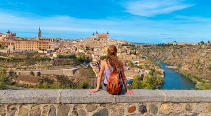 Woman tourist contempling panoramic view of Toledo citadel and river- Spain - obrazy, fototapety, plakaty