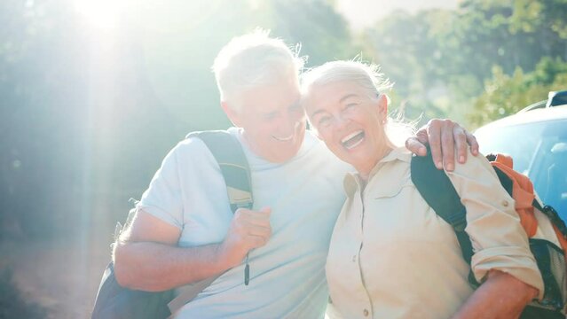 Portrait of smiling senior couple with backpacks going for hike in countryside standing by car together - shot in slow motion