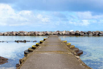 Obraz premium Hawaii Beach with Stone Pier and Steps to a Swimming Area