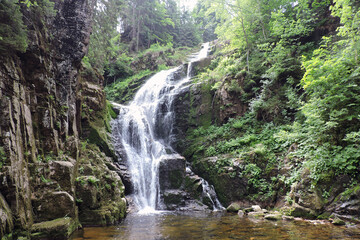 Fototapeta na wymiar Kamieńczyk Waterfall, the highest waterfall in the Polish part of The Karkonosze Mountains falling from a rocky wall to the Kamieńczyk Gorge