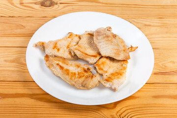 Grilled chicken steaks on a dish on the rustic table