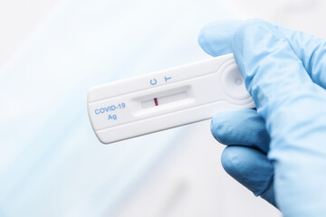 Doctor holding a negative result for COVID-19 with test kit for viral disease.