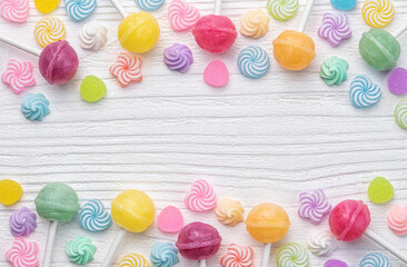Fototapeta na wymiar Sweet lollipops and candies on white wooden background