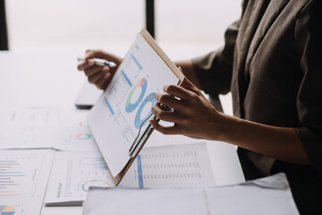 Financial analysts analyze business financial reports on a digital tablet planning investment project during a discussion at a meeting of corporate showing the results of their successful teamwork.