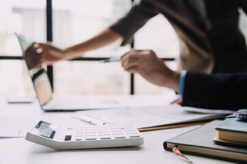 Financial analysts analyze business financial reports on a digital tablet planning investment project during a discussion at a meeting of corporate showing the results of their successful teamwork.