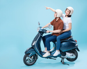 Young Asian couple ride scooter on background © Timeimage