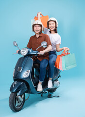 Young Asian couple ride scooter on background