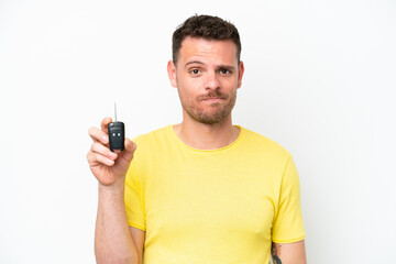 Young man holding car keys isolated on white background with sad expression