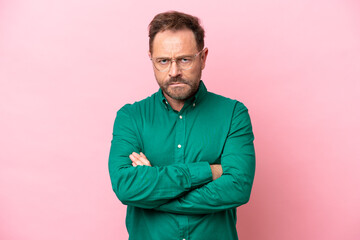 Middle age caucasian man isolated on pink background with unhappy expression