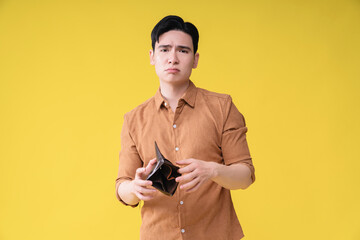 Young Asian man with empty wallet on background