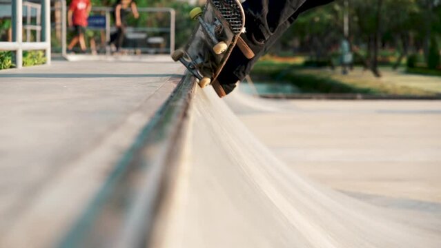 Close up of skateboard sliding on halfpipe ramp