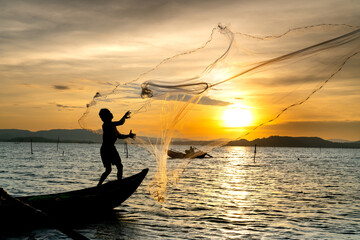 Fishermen are throwing fishing nets into on the river in the sunset in Phu Yen province, Vietnam