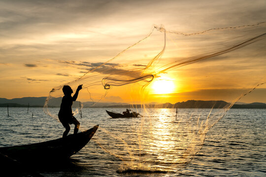 Fishermen are throwing fishing nets into on the river in the sunset in Phu Yen province, Vietnam