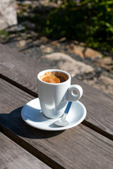 A cup of coffee on a table against the backdrop of nature in the garden