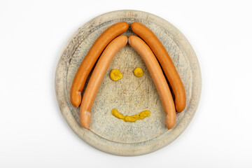 Frankfurter Sausages with Mustard on Wooden Plate - Delicious German Food Concept in Shape of a Face