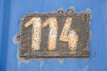 Old retro weathered cast iron plate with number 114