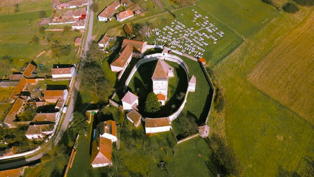 Aerial view of the fortified church in Hosman village, Romania. Video was shot from a drone while flying in an orbit with the camera tilted downwards for a top view shoot of  the fortification.
