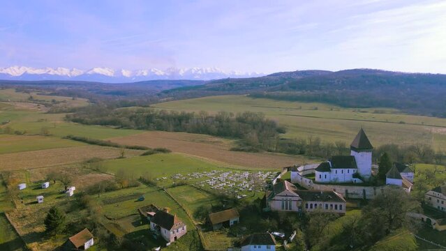 Aerial video of the fortified church located in Hosman village, Sibiu county, Romania. Footage was shot from a drone while flying at low altitude and panning right with the fortification in the view.
