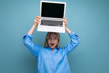 photo of shocked surprised cute blond girl with open laptop with blank space for website on blue background