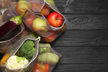 Different fresh vegetables in bags on wooden table, top view with space for text. Farmer harvesting