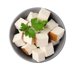 Bowl of delicious smoked tofu cubes with parsley isolated on white, top view
