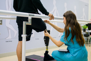 Nurse helping patient to walk between barbells at health care center