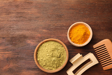Comb, hair clip, henna and turmeric powder on wooden table, flat lay. Space for text