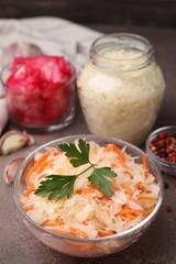 Delicious sauerkraut prepared according to different recipes on brown table, closeup view