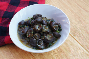 Kaeng Hoi Khom, River snails or Periwinkle curry on white bowl. Concept : Edible snails that can be cooked in various delicious menu. Weird food. Thai taditional local food.                           