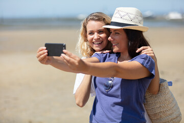 cheerful girls friends in summer taking a selfie