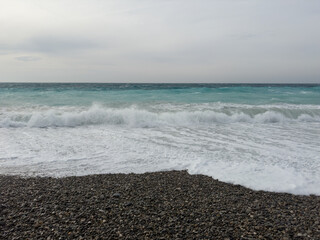 Pebble beach of Nice, France with azure waves of mediterranean sea