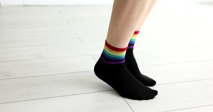 Feet in black socks with lgbt flag jumping on floor closeup 4k movie slow motion. Gender equality concept