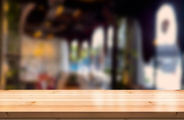 Empty wooden table top with lights bokeh on blur restaurant background.