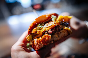 man hands eat fast food burger in pub