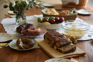 Close-up of Easter breakfast table with traditional slovenian dishes. Ham, colorful eggs, potica and horseraddish.