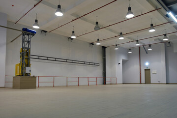 An Interior of a  large illuminated empty industrial space