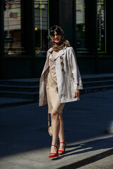 A girl in glasses walks around the city