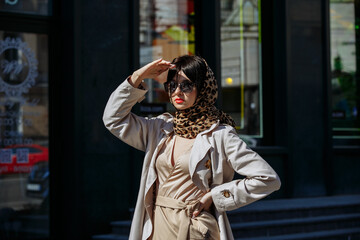 Fototapeta na wymiar A girl in glasses walks around the city