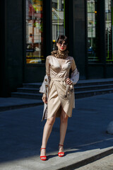 A girl in glasses walks around the city