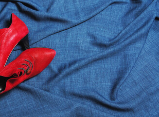 Red suede evening shoes on a blue background