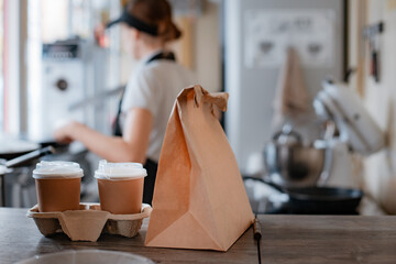 Buying fast food. A pancake with filling and a paper cup with coffee in the hands of a woman seller...