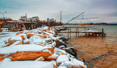 Typical fishing net and fisher house with over the sea in Marina di Pisa after a snowstorm -...